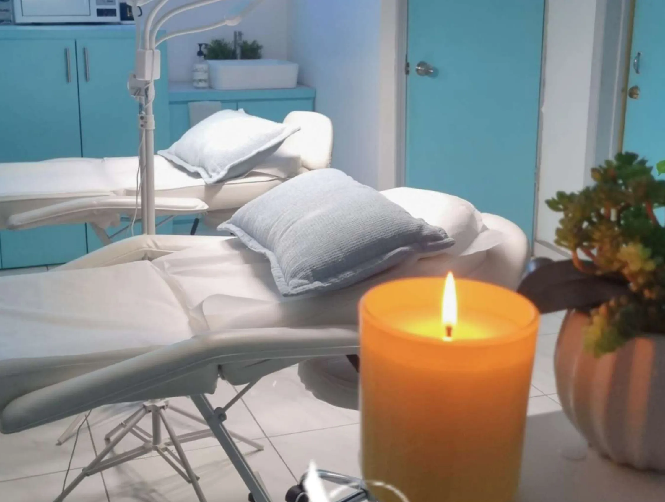 Interior of Ana George Studio: treatment beds, a work lamp and a lit candle